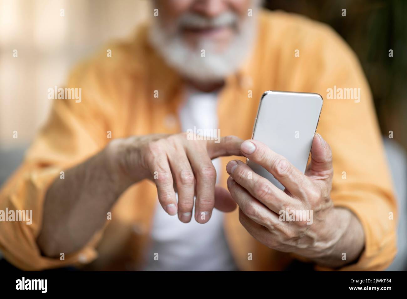 Cropped of senior man using smartphone at home Stock Photo