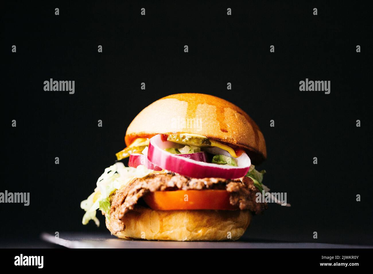 Doble cheeseburger with vegetables over a black background Stock Photo