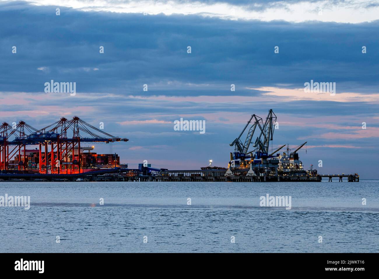 Jade-Weser-Port, container terminal in Wilhelmshafen, cargo handling of a large container ship (left and a general cargo ship (right) Stock Photo