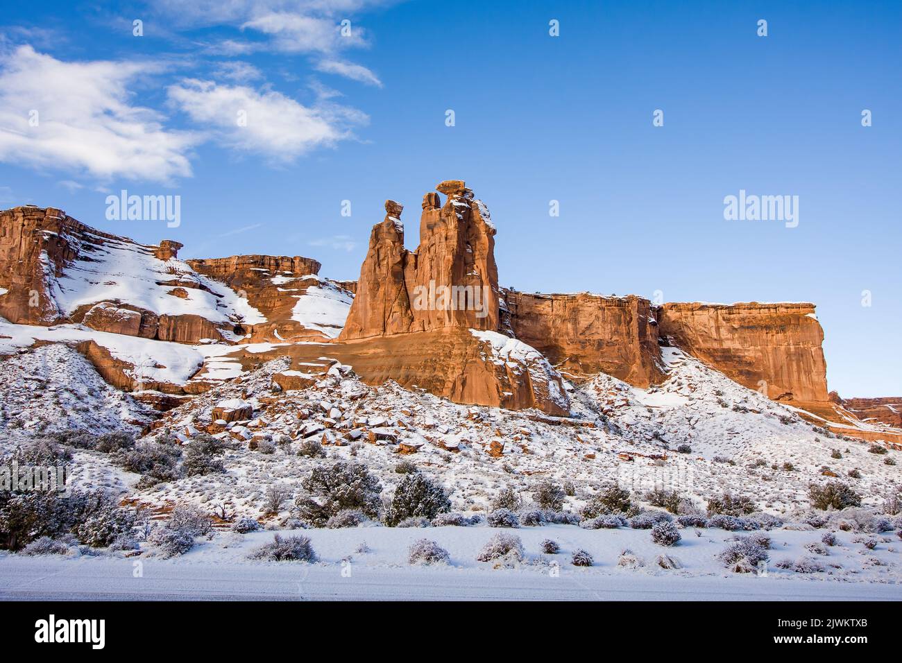 The hoodoos known as the Three Gossips in the Courthouse Towers with snow in winter.  Arches National Park, Moab, Utah. Stock Photo