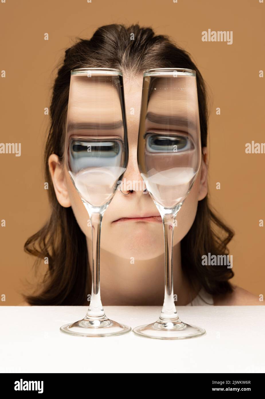 Contemporary art portrait of pretty girl looking through glass of water