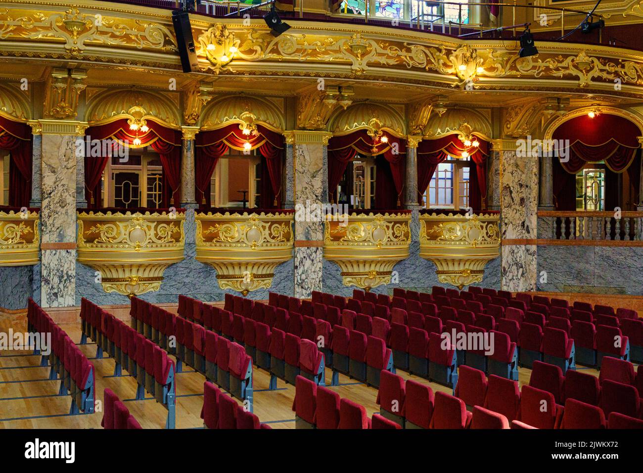 The Grand Hall inside The Royal Hall with rows of seating with box seating surrounded with vibrant gold decoration, Harrogate, North Yorkshire, UK. Stock Photo
