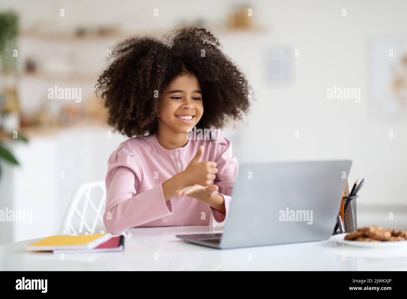 Happy black schooler looking at laptop screen, showing thumb up Stock ...