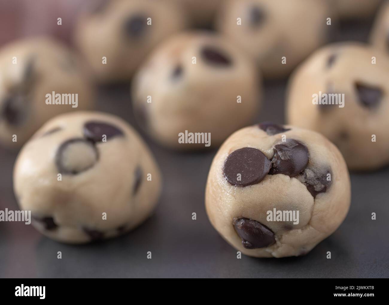Chocolate chip cookie dough balls closeup on baking sheet. Stock Photo