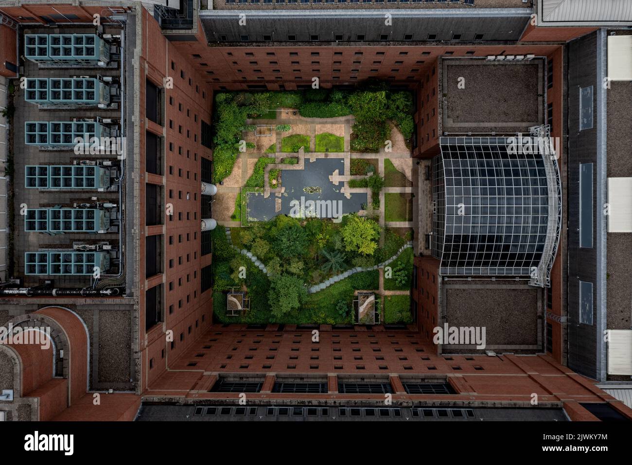 An aerial view directly above a secluded inner courtyard garden in the centre of a city apartment block surrounded by red brick walls Stock Photo