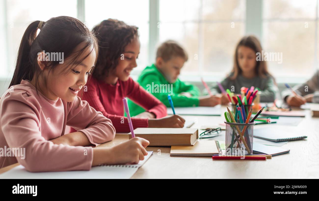 Japanese Schoolgirl Taking Notes Writing Essay Learning In Classroom