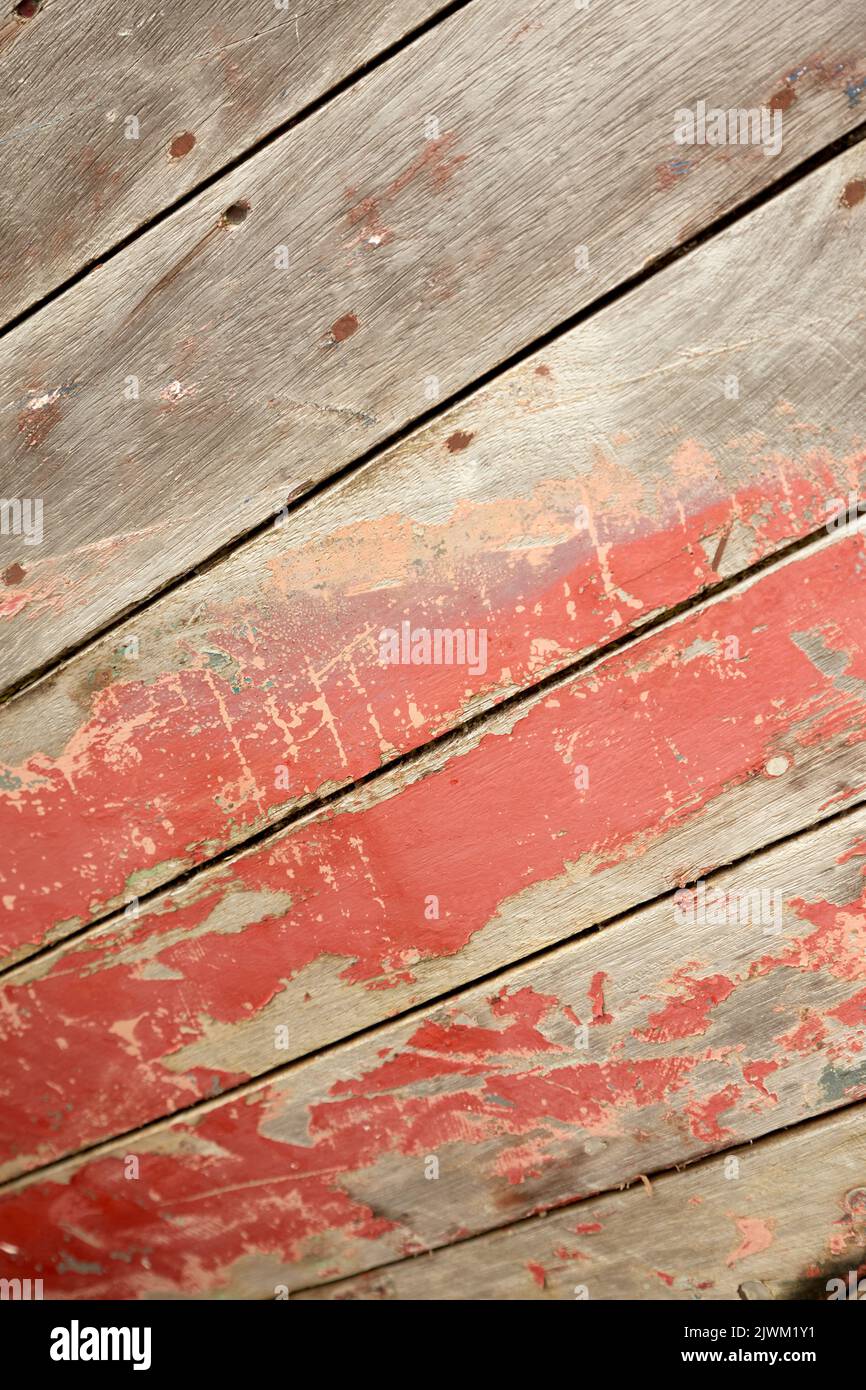 Close-up of a worn surface of a red painted wooden boat. Stock Photo