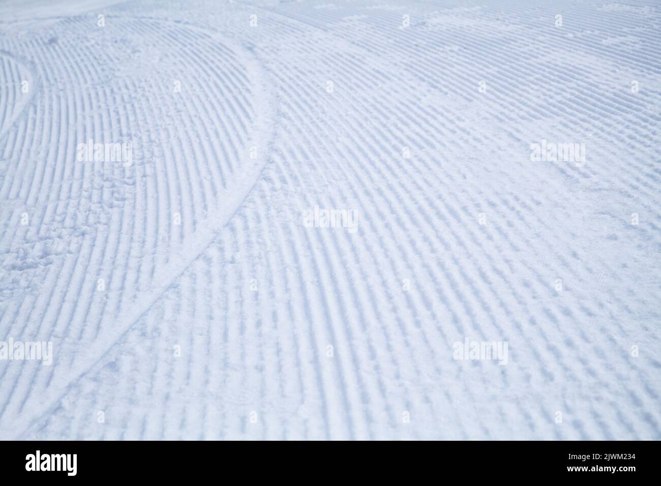 Striped texture of a snowy ski slope, winter sports background photo Stock Photo