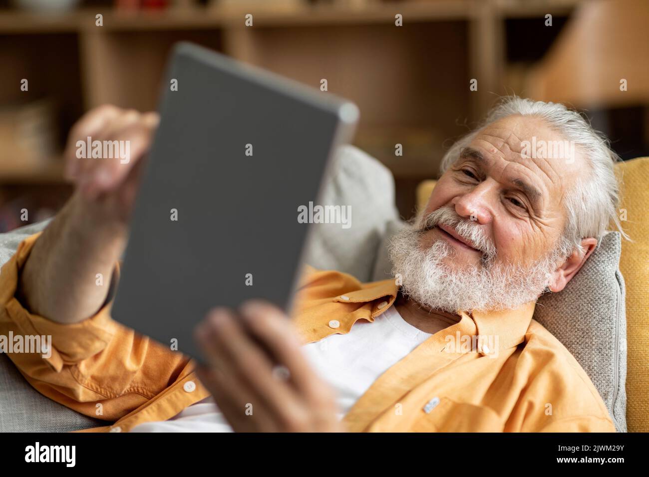 Cheerful senior man using digital tablet at home Stock Photo