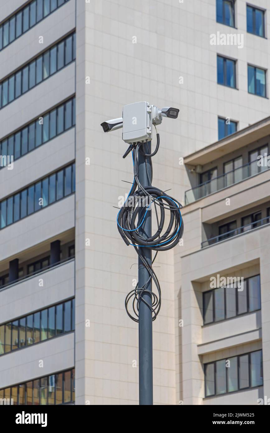 CCTV Surveillance Camera Pole With Hanging Cables and Wires Stock Photo