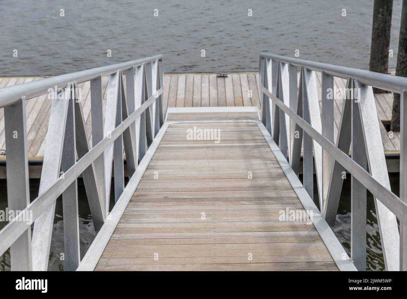 The steep walkway going down to a boat launch pier. Stock Photo