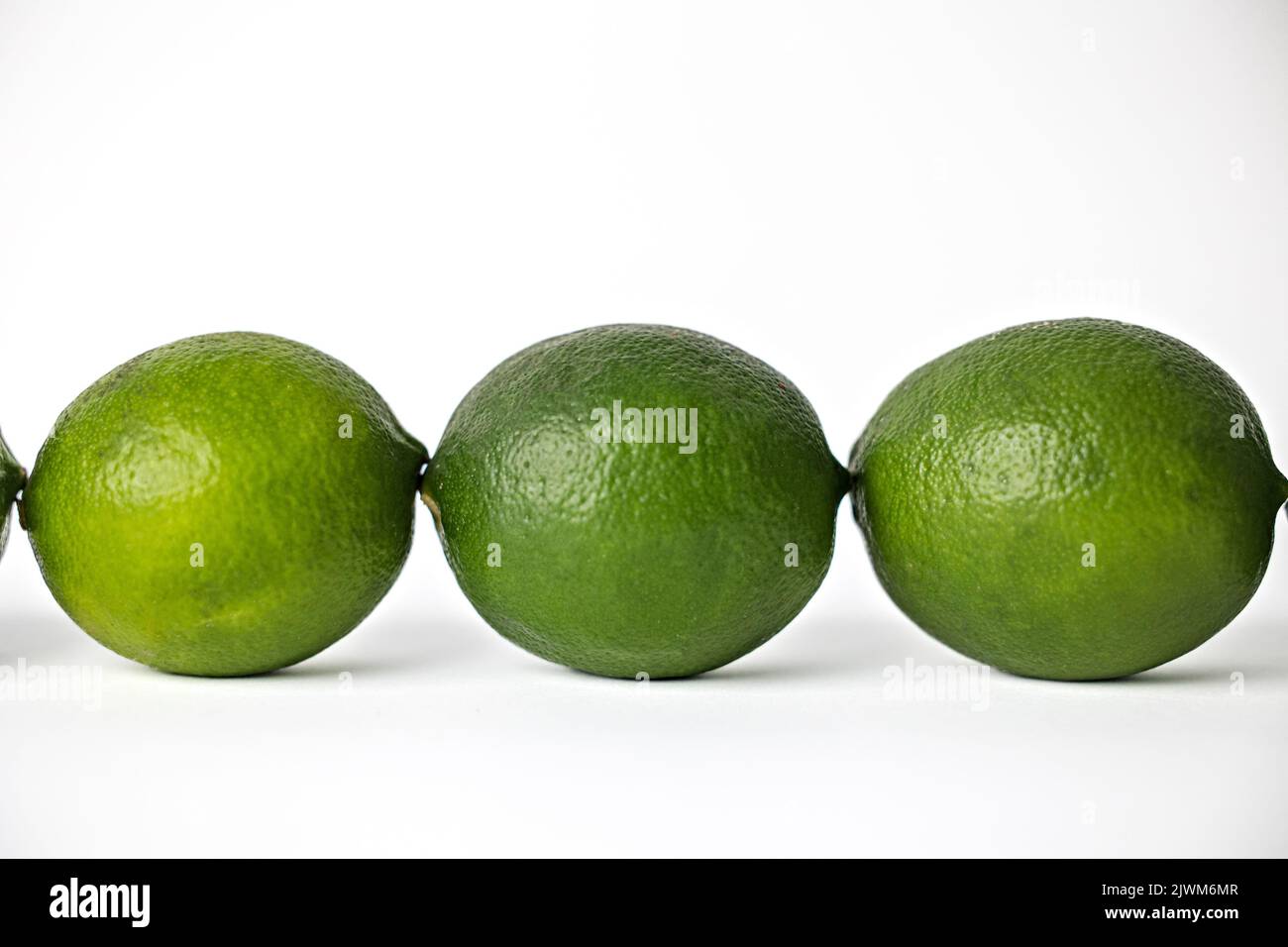 a row of three homegrown organic limes fruit in the summer. Stock Photo