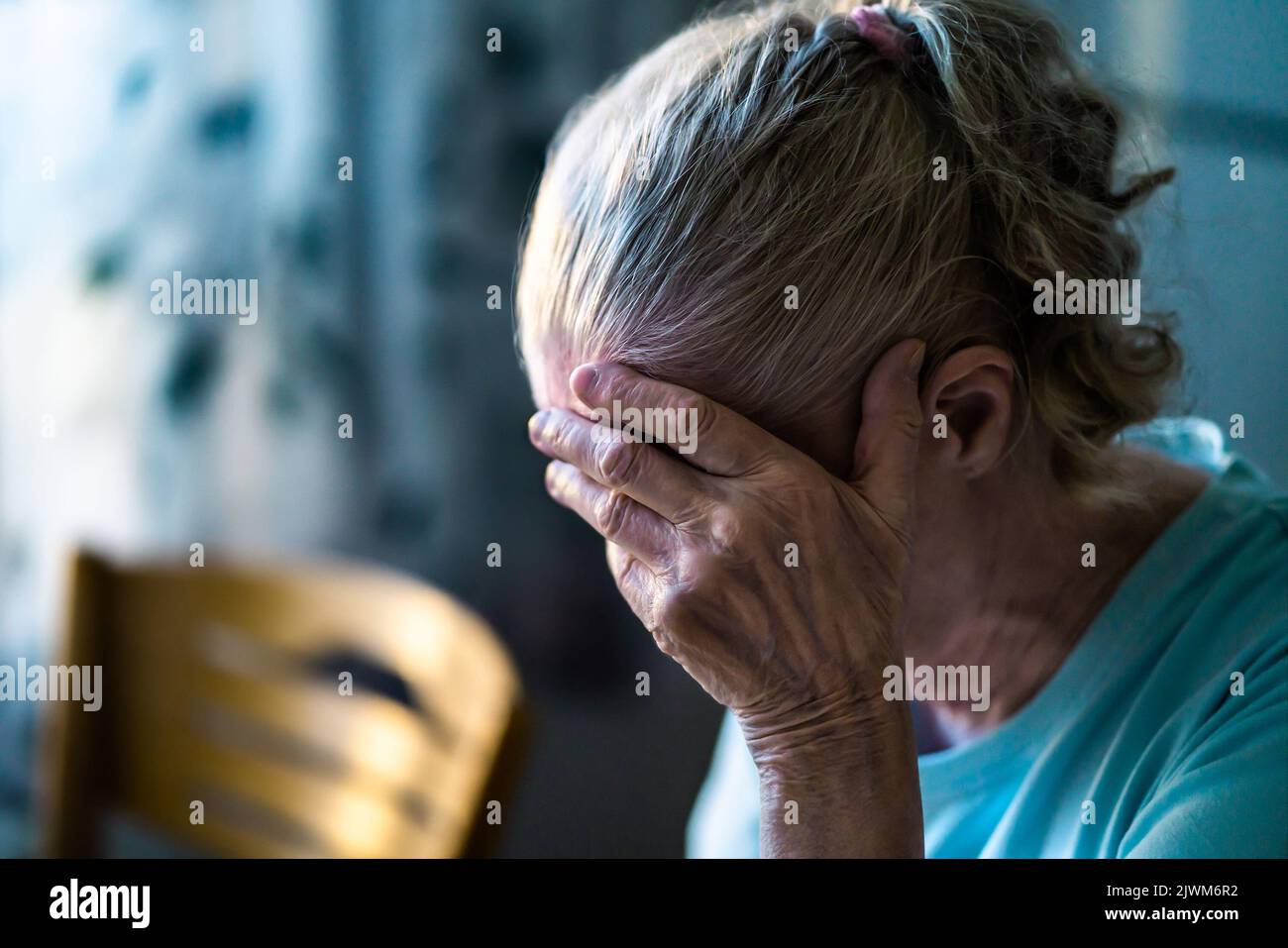 Sad senior old woman. Lonely from loss or sick with headache. Upset patient in retirement home with stress or pain. Alzheimer, depression, senility. Stock Photo