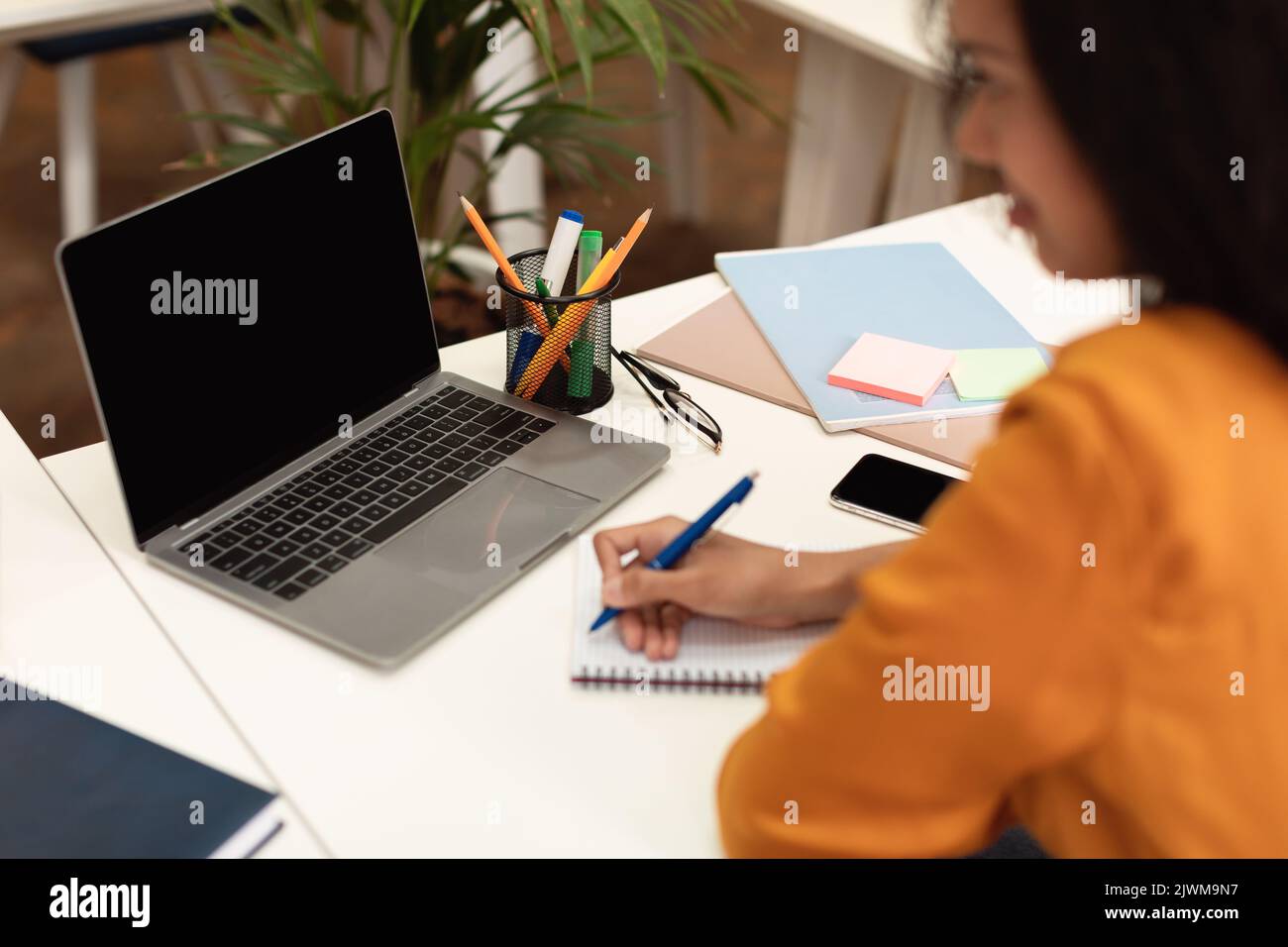Online class concept. Black female student writing in notebook, taking