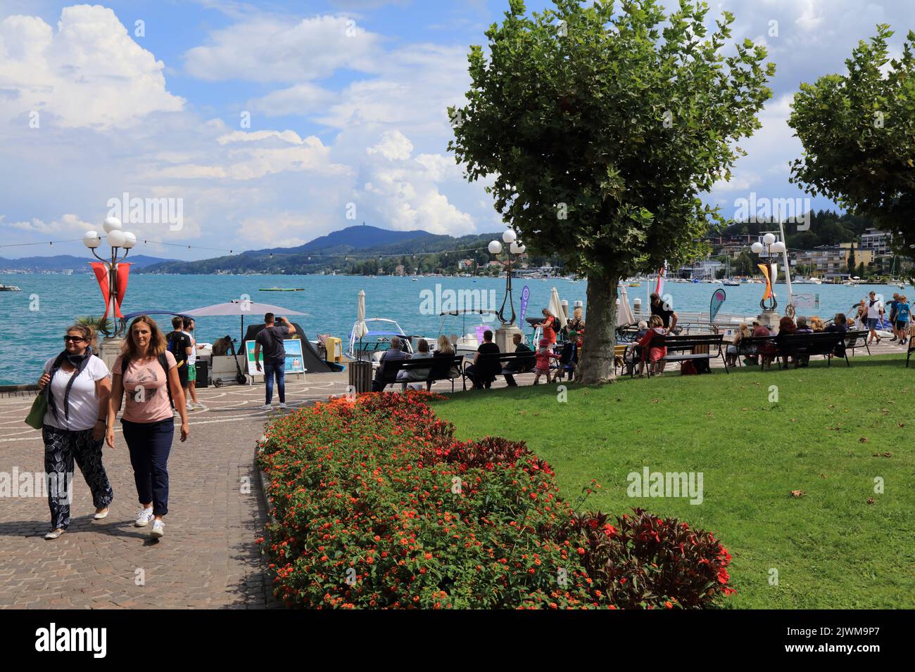 VELDEN AM WORTHER SEE, AUSTRIA - AUGUST 12, 2022: People visit lake Worthersee in Velden Am Worther See resort town in Carinthia, Austria. Stock Photo
