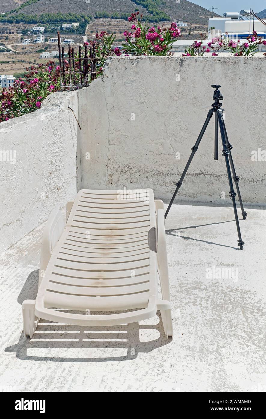 The unidentified building terrace with tripod and a lounge chair on Paros, Greece Stock Photo