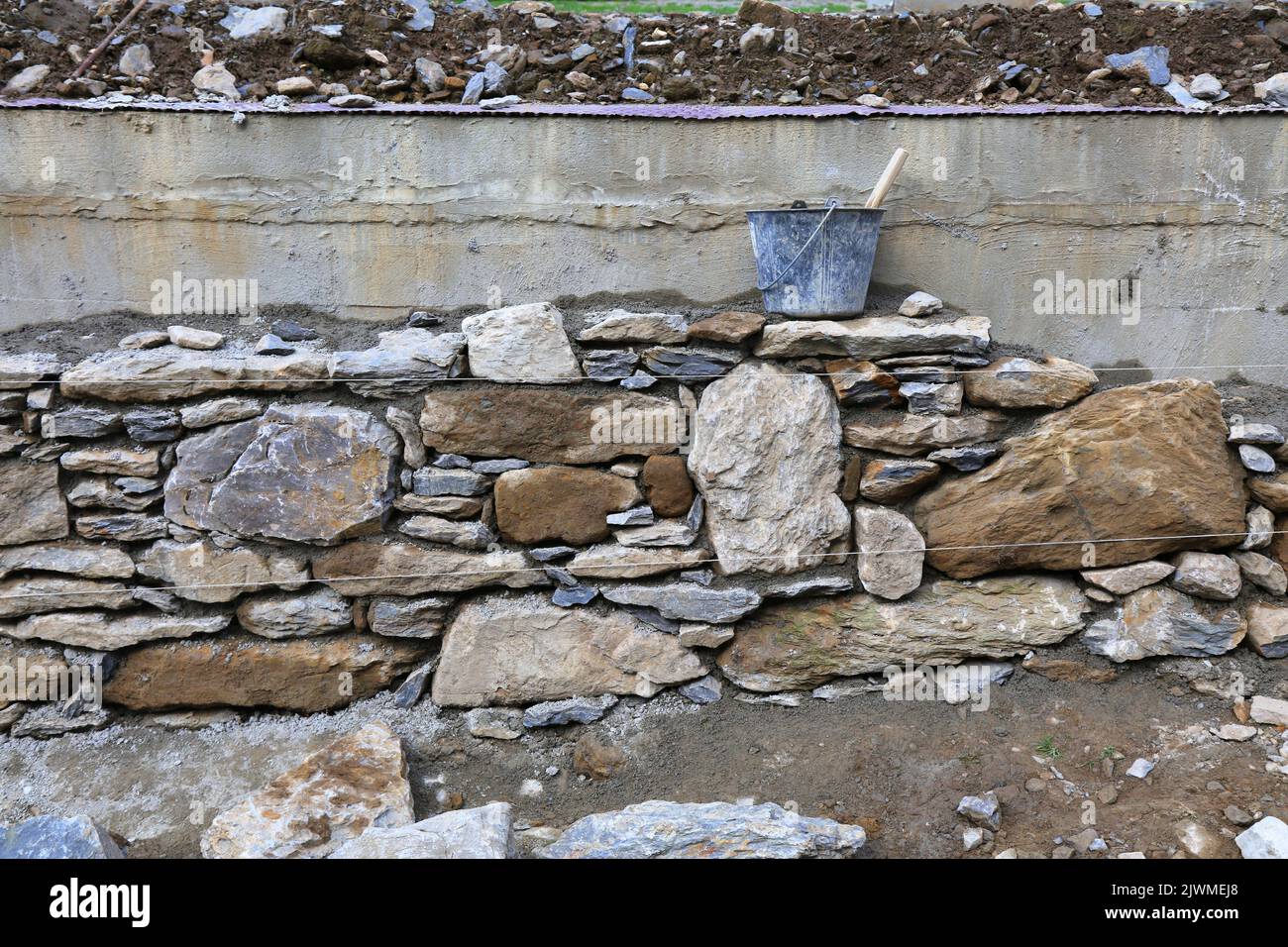 Traditional natural stone masonry wall in France. Construction of