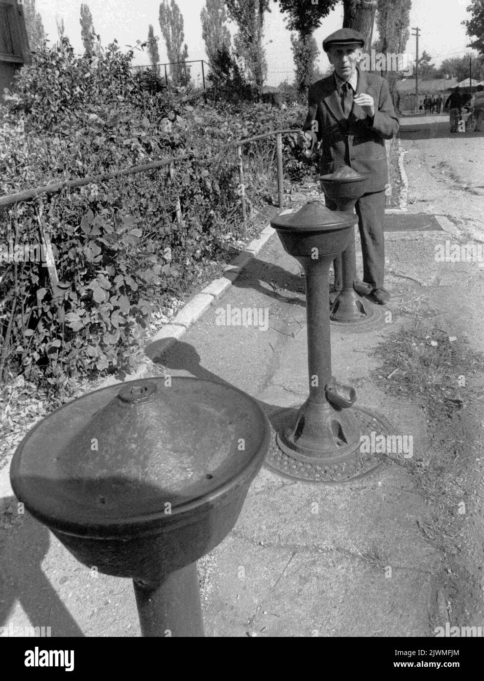 Bucharest, Romania, 1990. Man in front of a water fountain on the street. Stock Photo