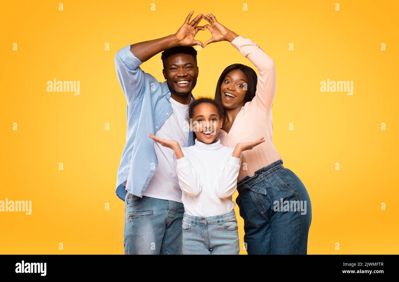 Excited black parents showing heart shape with fingers, making symbolic