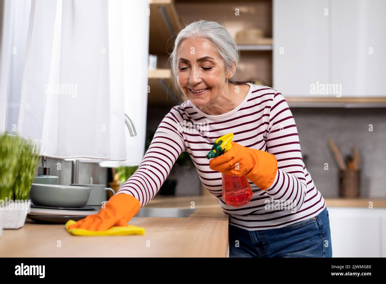 Portrait of smiling man cleaning the kitchen worktop at home Stock Photo -  Alamy