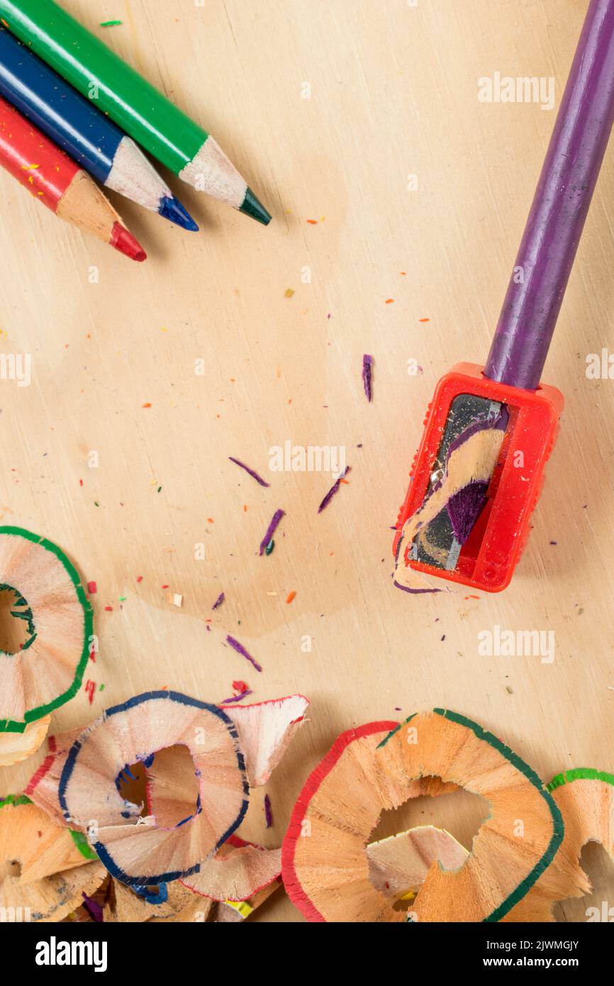 Sharpening a colored pencil on a wooden table Stock Photo