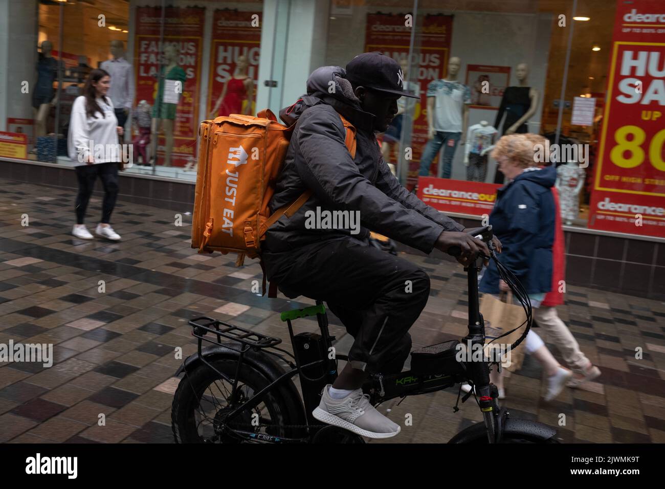 Fast food delivery couriers, for Deliveroo, and Just Eat, in Glasgow, Scotland, 6 September 2022. Stock Photo