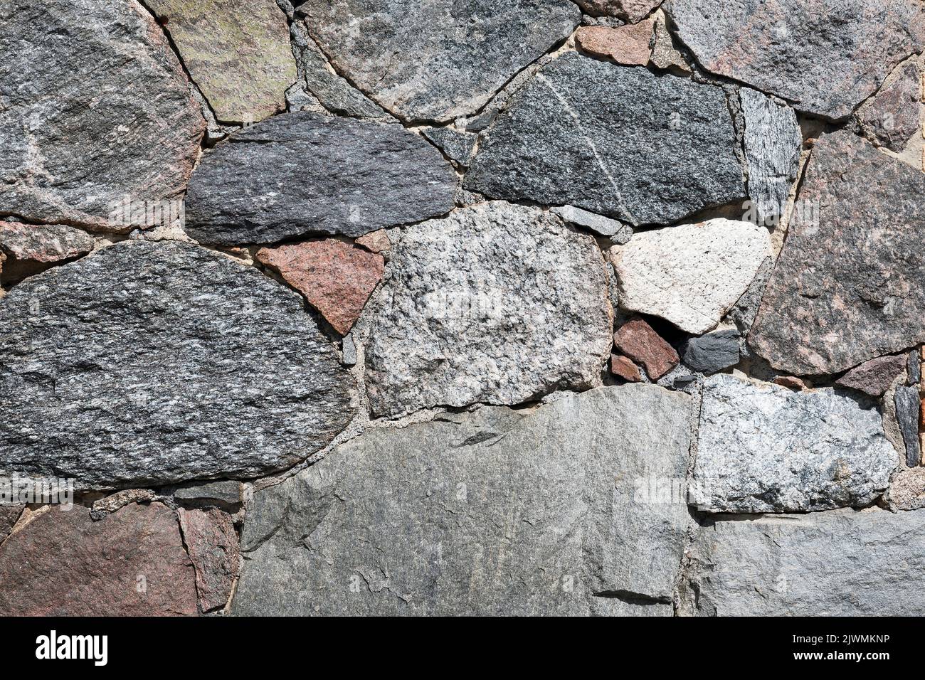 Stone wall with different colors and size of rocks Stock Photo