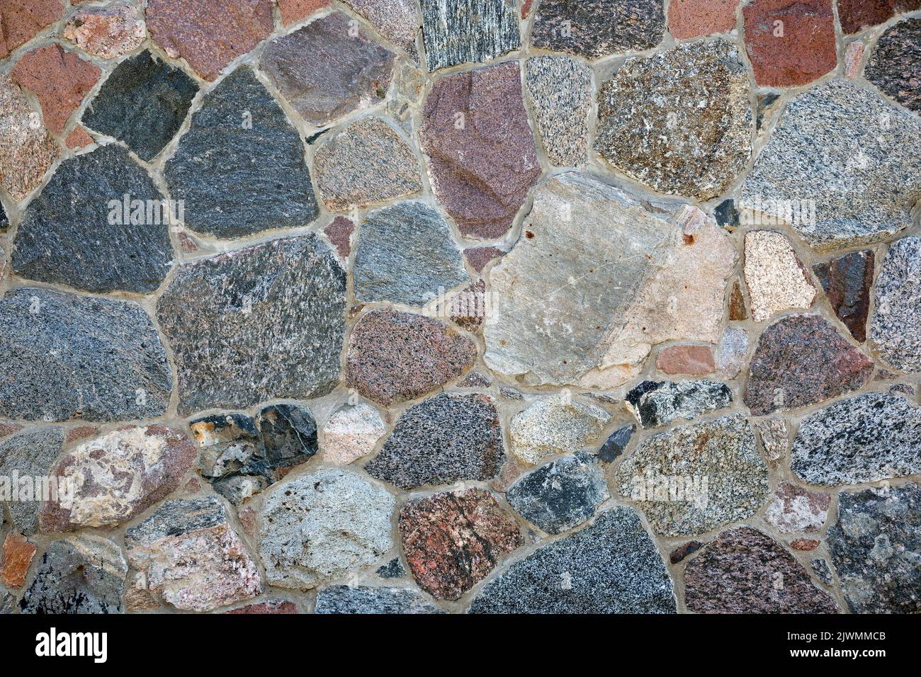 Stone wall with different colors and size of rocks Stock Photo