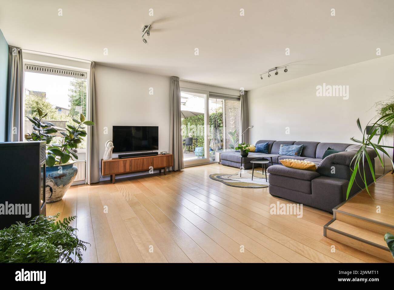 Contemporary luxury design of living room with kitchen and dining table near window Stock Photo