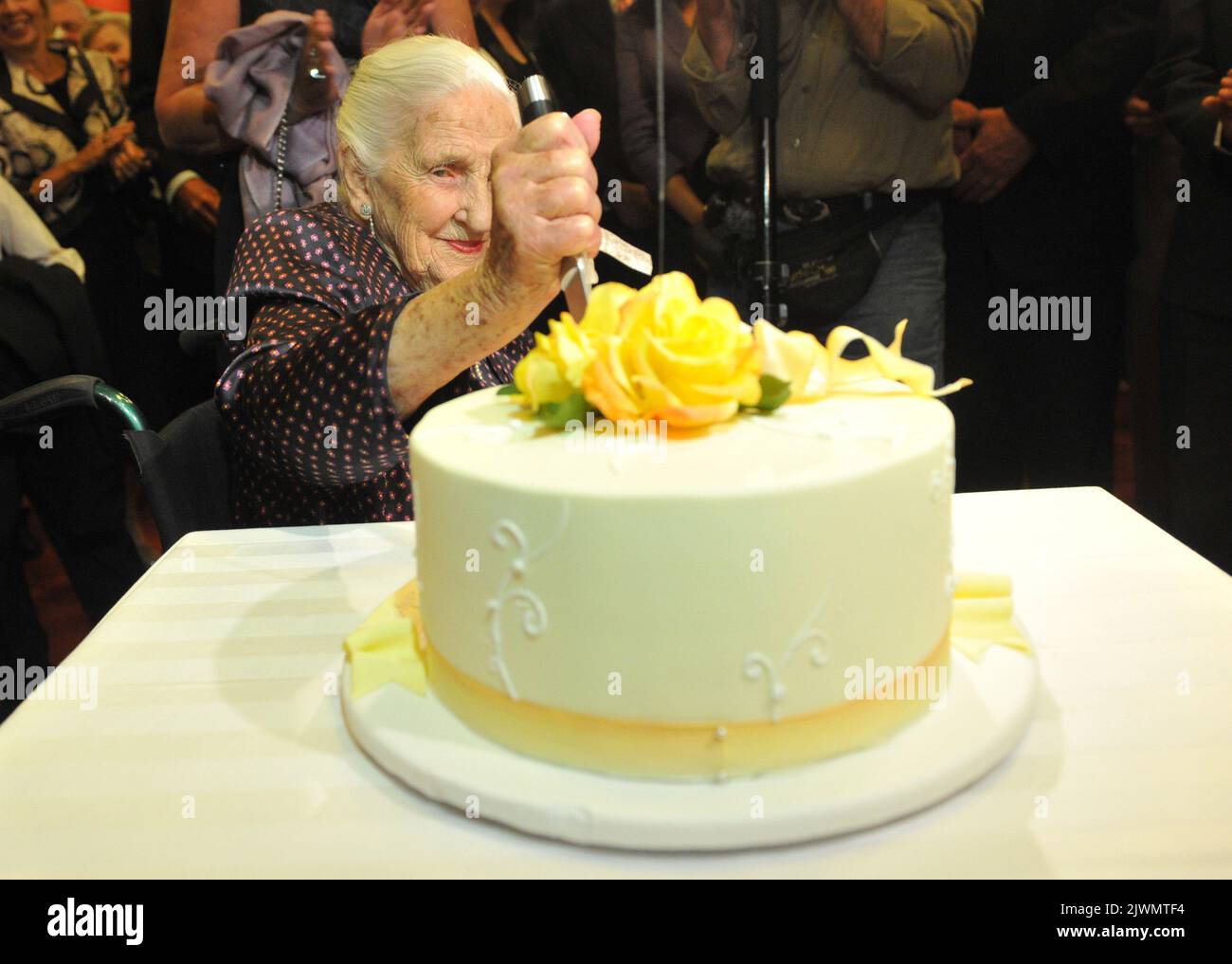 Dame Elisabeth Murdoch cuts into her 102nd birthday cake at the