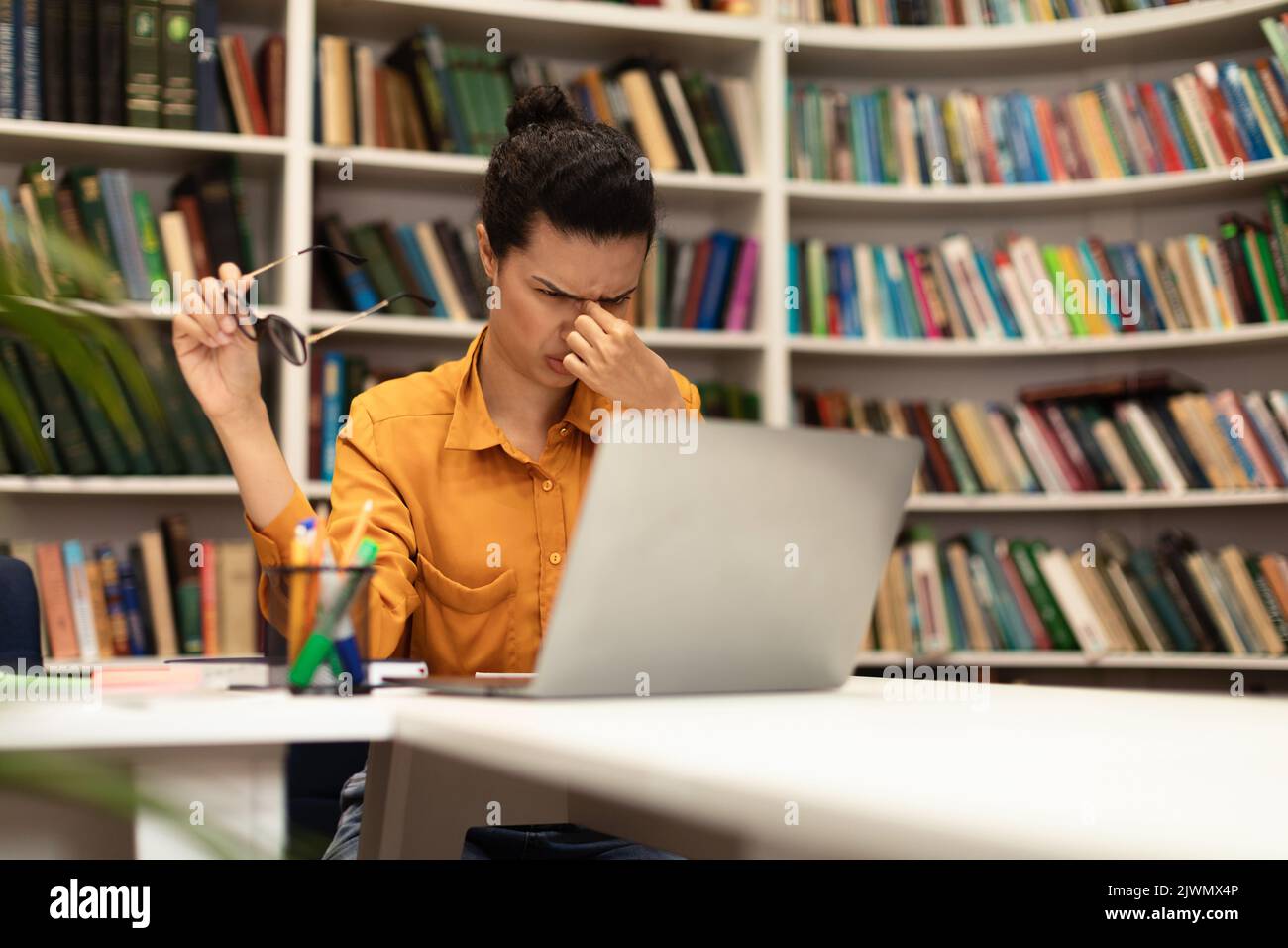 Eyes fatigue. Latin lady rubbing eyes and taking off eyeglasses