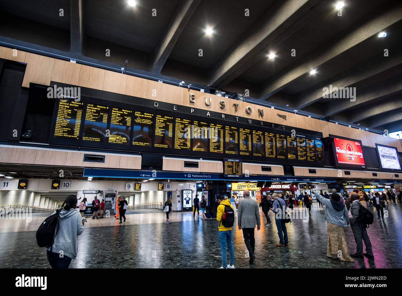 People look at the departure boards in Euston Station, London Stock Photo