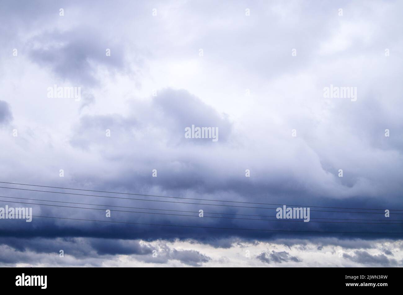 Power lines with dark clouds in the background Stock Photo - Alamy