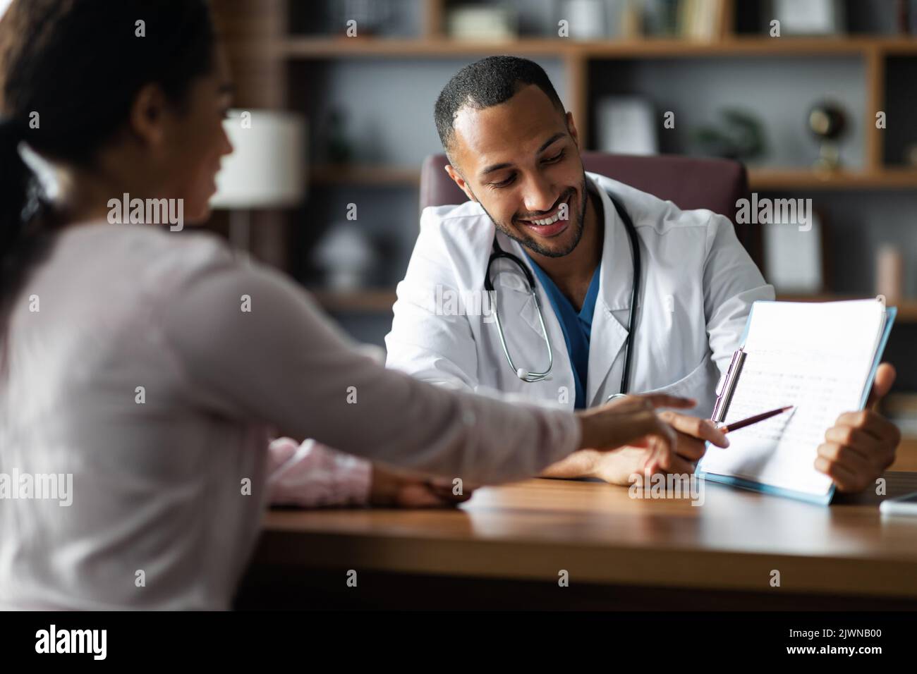 Handsome middle eastern doctor having conversation with black woman ...