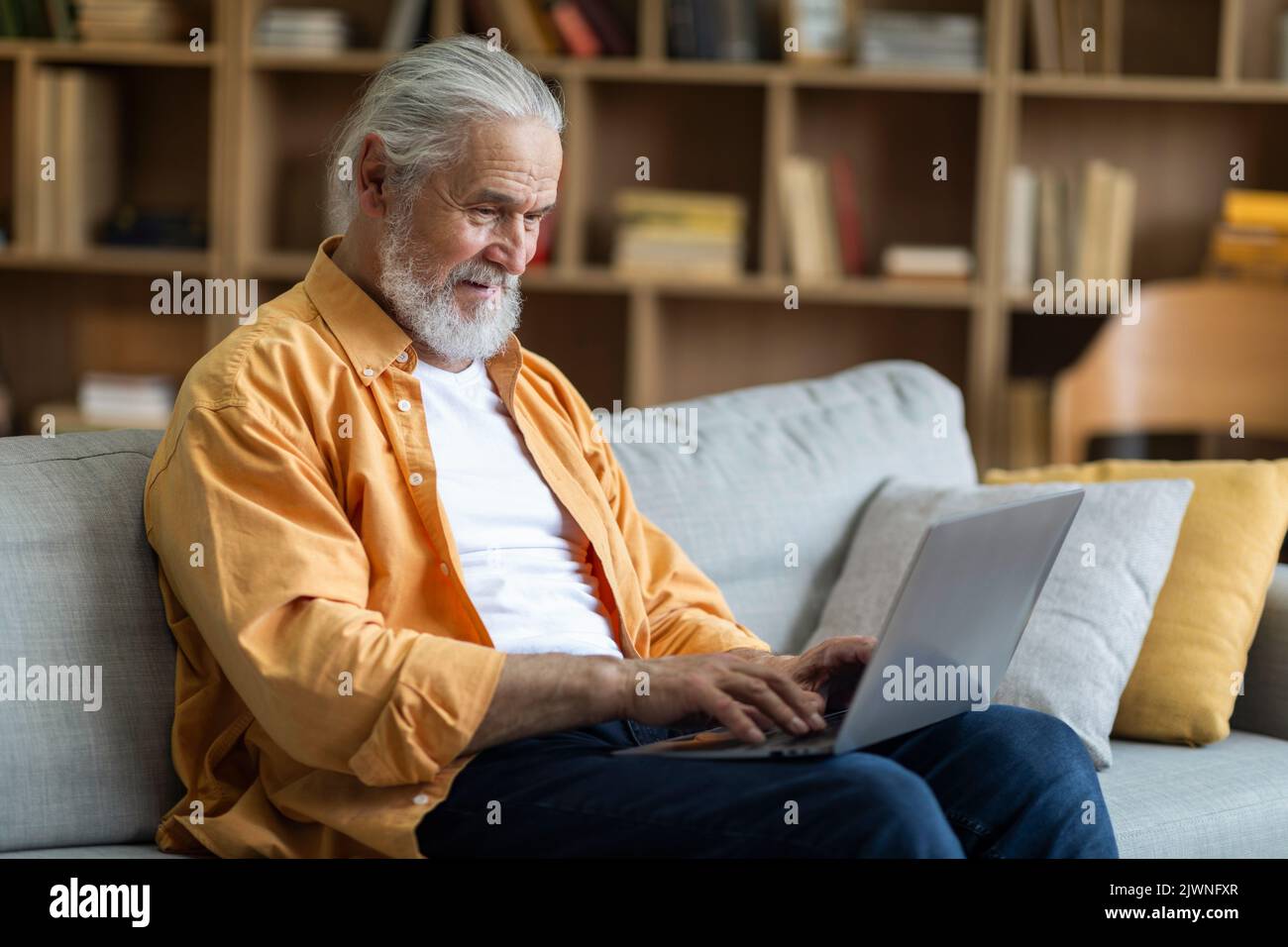 Side view of elderly man using computer at home Stock Photo - Alamy
