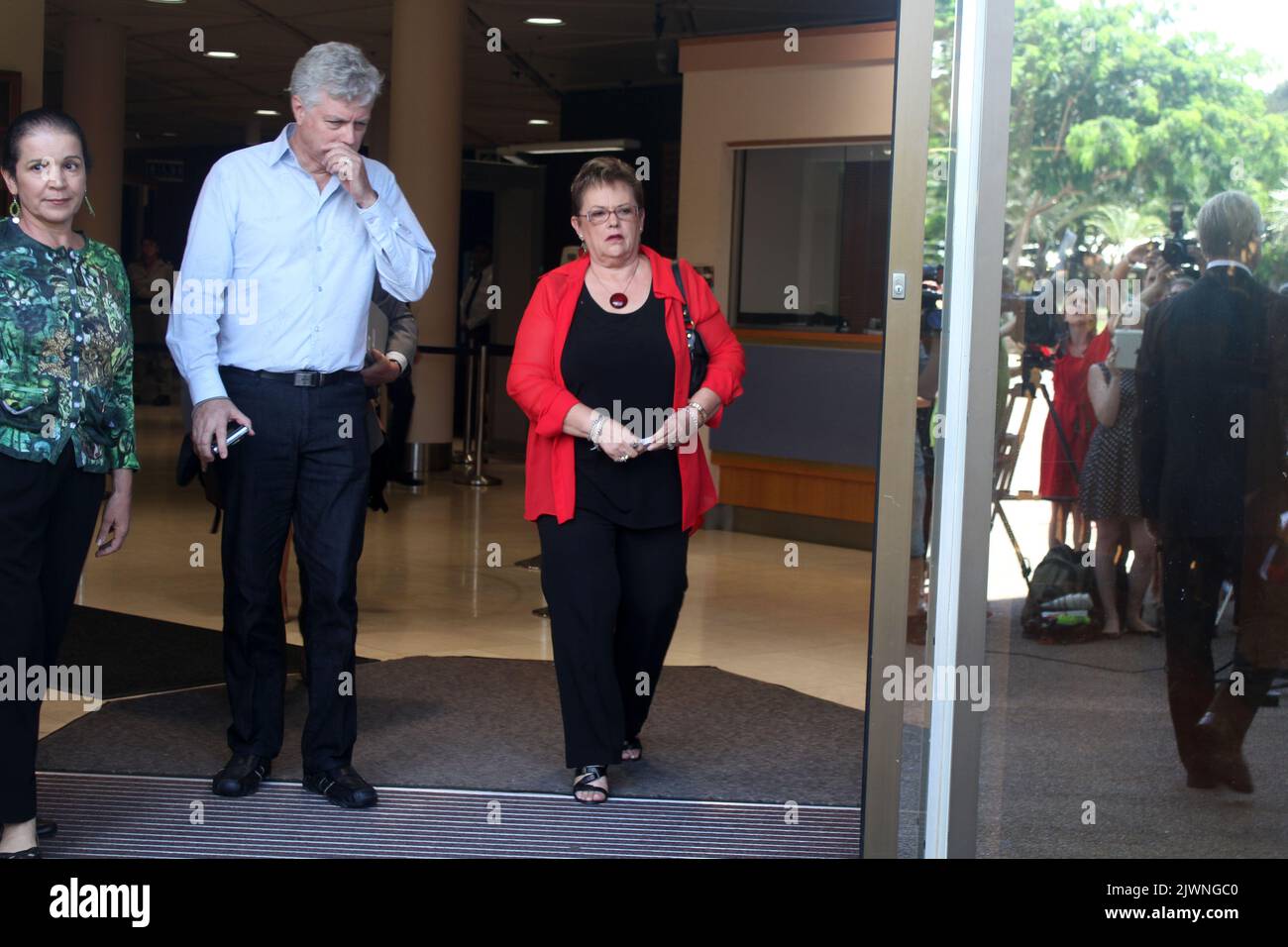 Lindy Chamberlain-Creighton (red jacket) is accompanied by her husband Rick Creighton as she exits the Magistrates Court in Darwin, Friday, Feb. 24, 2012. She had attended the inquest into the death of her daughter Azaria Chamberlain who disappeared from her parents' tent at Uluru (Ayers Rock) in August 1980. Image: Xavier La Canna Stock Photo