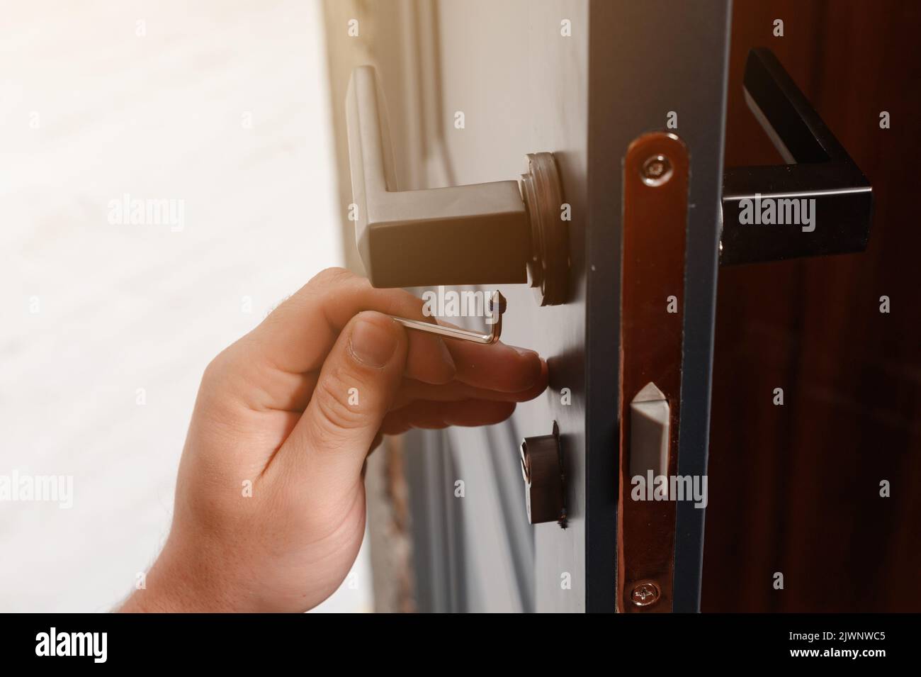 The craftsman installs the door handle with the help of a sprocket key