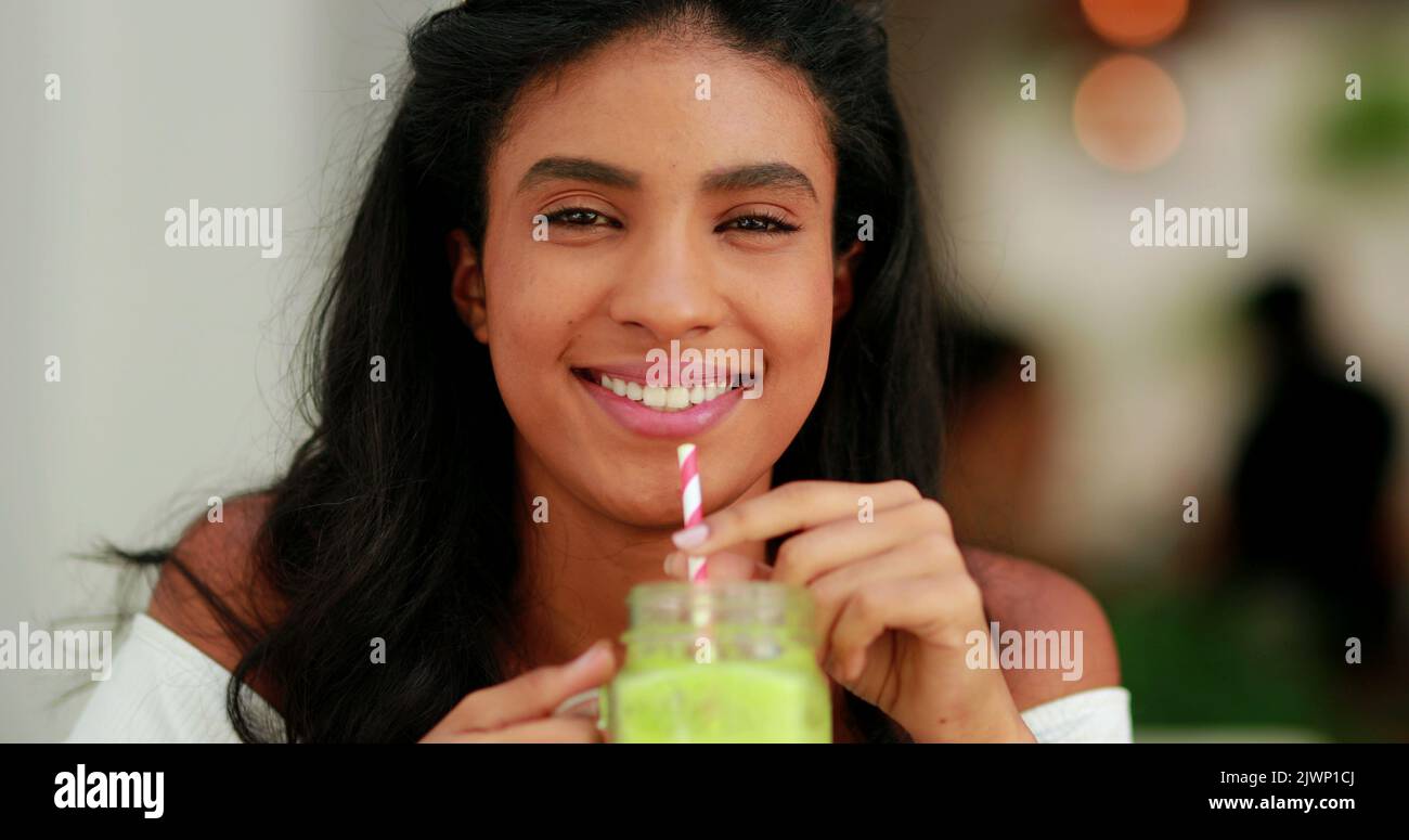 Pretty black girl drinking healthy green juice. Portrait of diverse