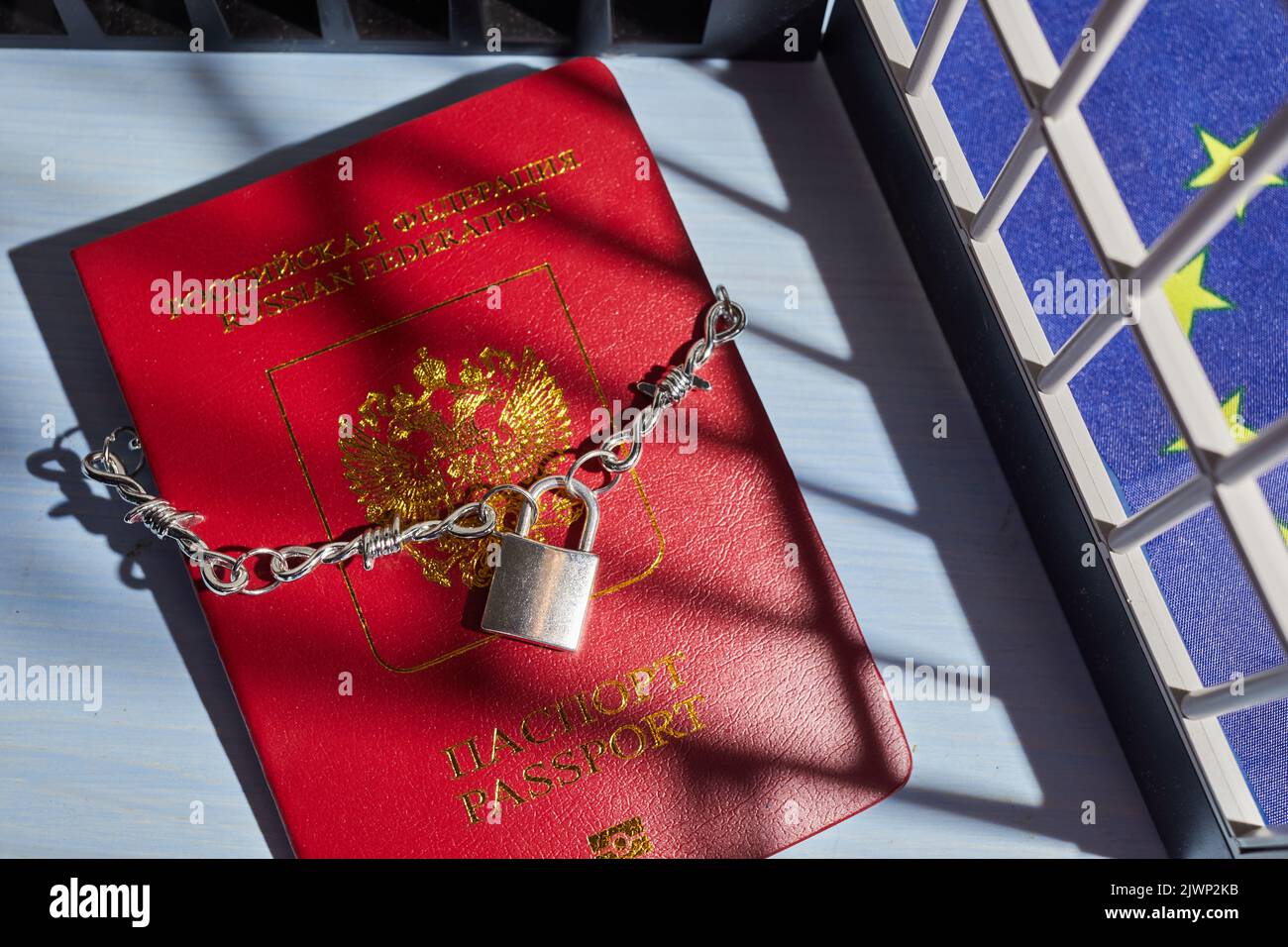 Russian passport chained in a chain with a padlock is located. Prohibition of Schengen visas for Russian tourists. Stock Photo