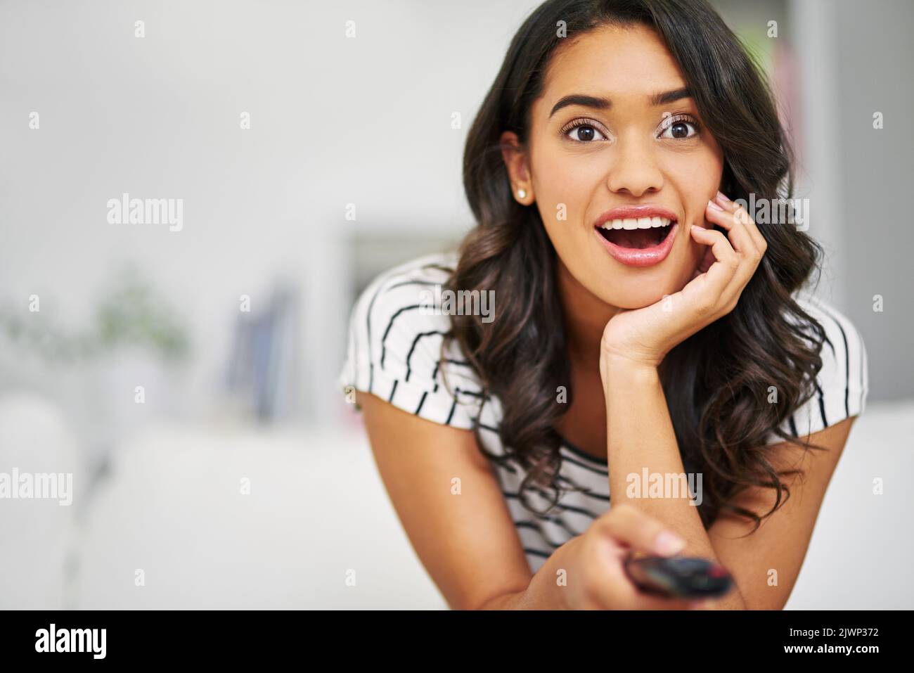 What a plot twist. a young woman watching TV while relaxing on her sofa ...