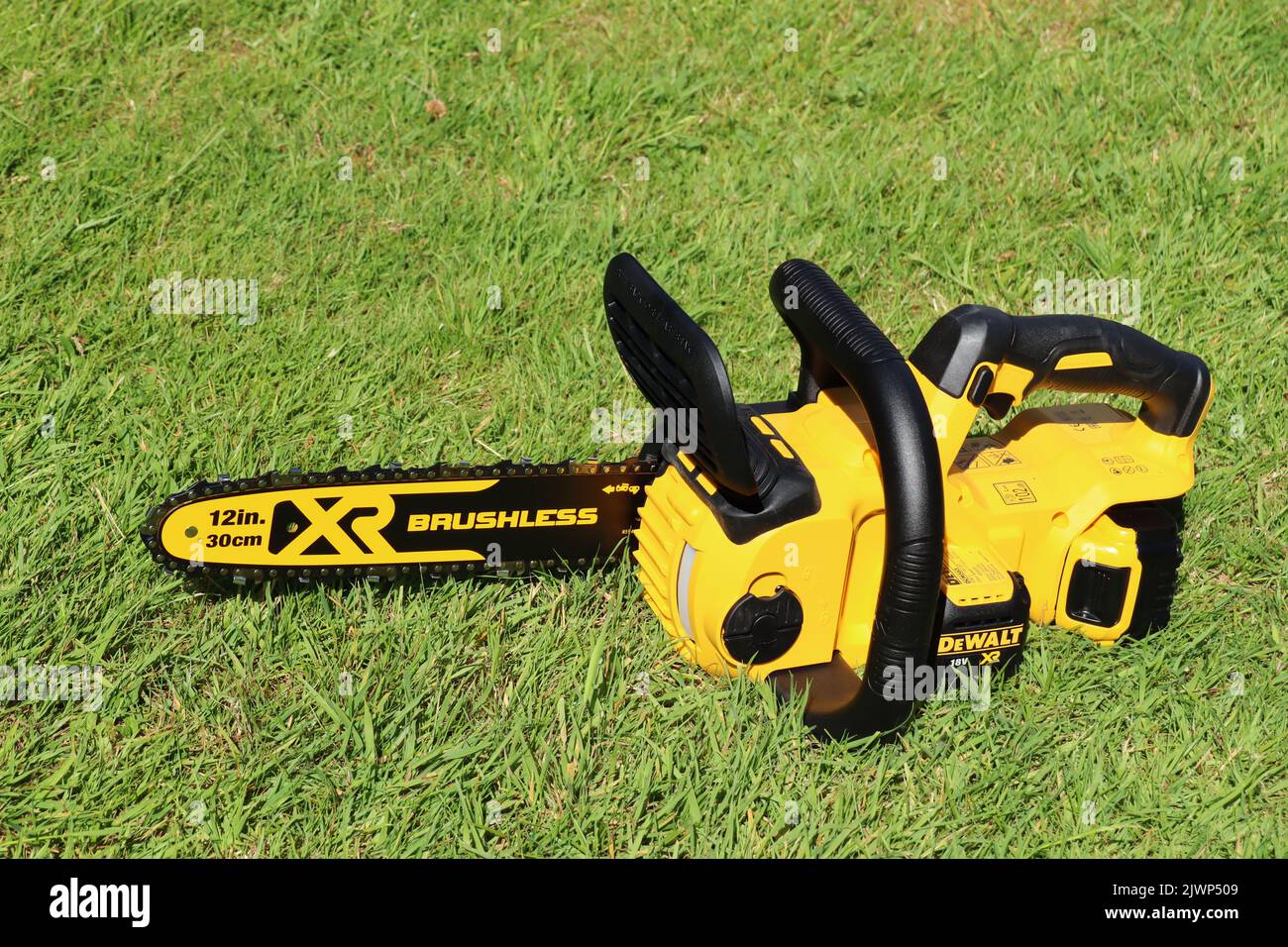 EXETER, DEVON, ENGLAND - JUNE 15TH 2021: Dewalt 18 volt cordless chainsaw on the lawn Stock Photo