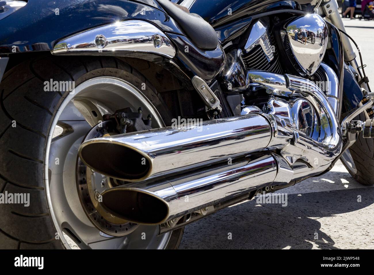 A fragment of a powerful motorcycle located on a sunny day in the square. Stock Photo