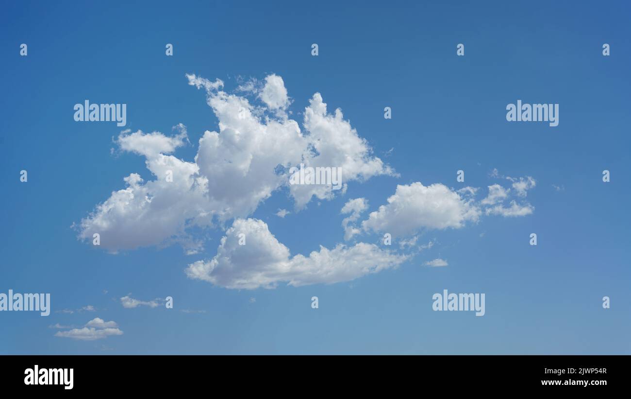Isolated puffy clouds and blue sky for background use or sky substitution Stock Photo