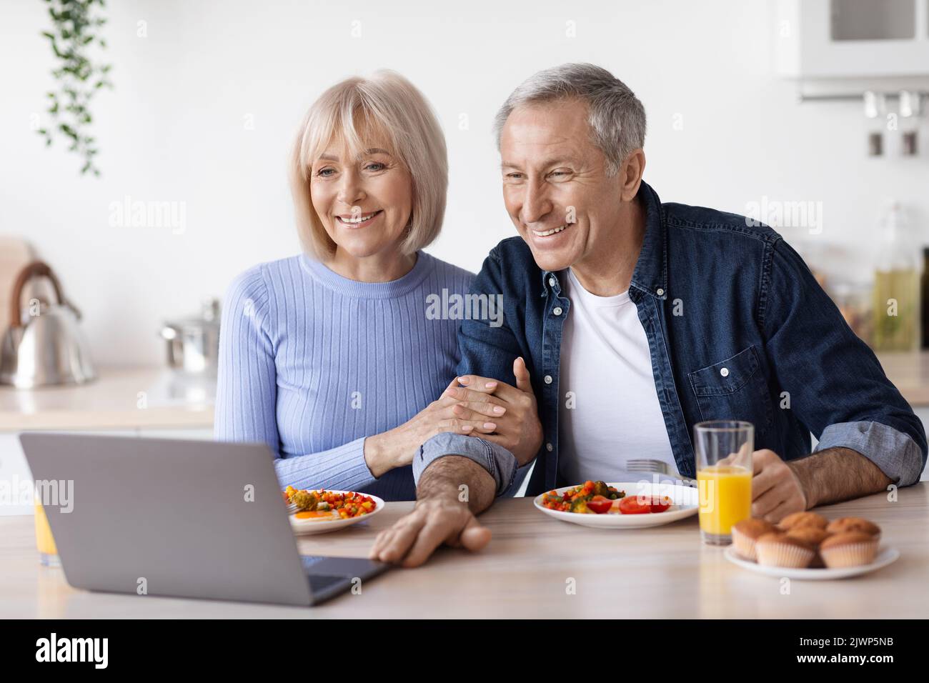 Loving senior couple having video call while having breakfast Stock Photo