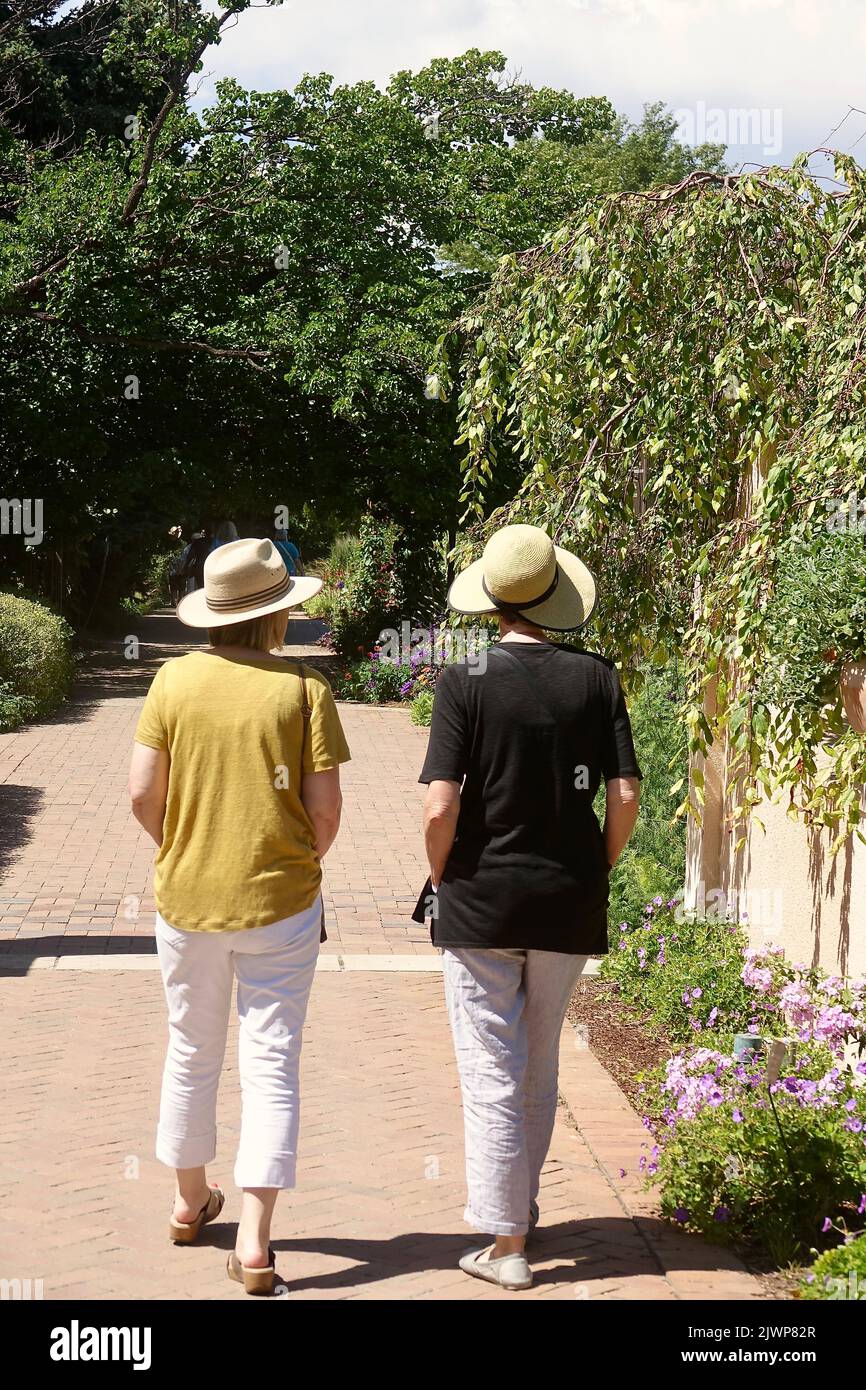 two women wearing straw hats going for a walk in the park Stock Photo ...