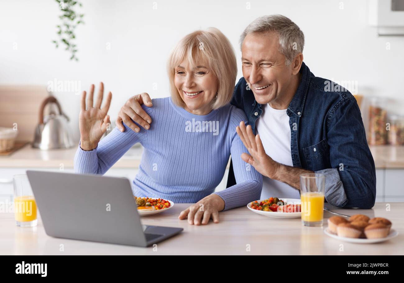 Happy senior couple making video call while having breakfast Stock Photo