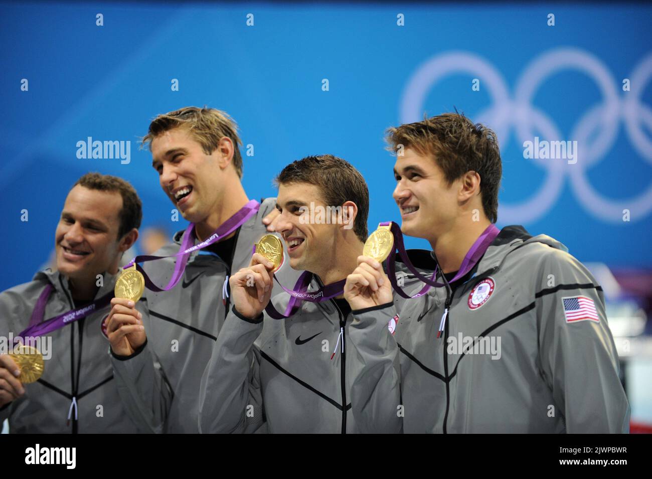 The USA's Michael Phelps (2nd from right) holds his gold medal with his
