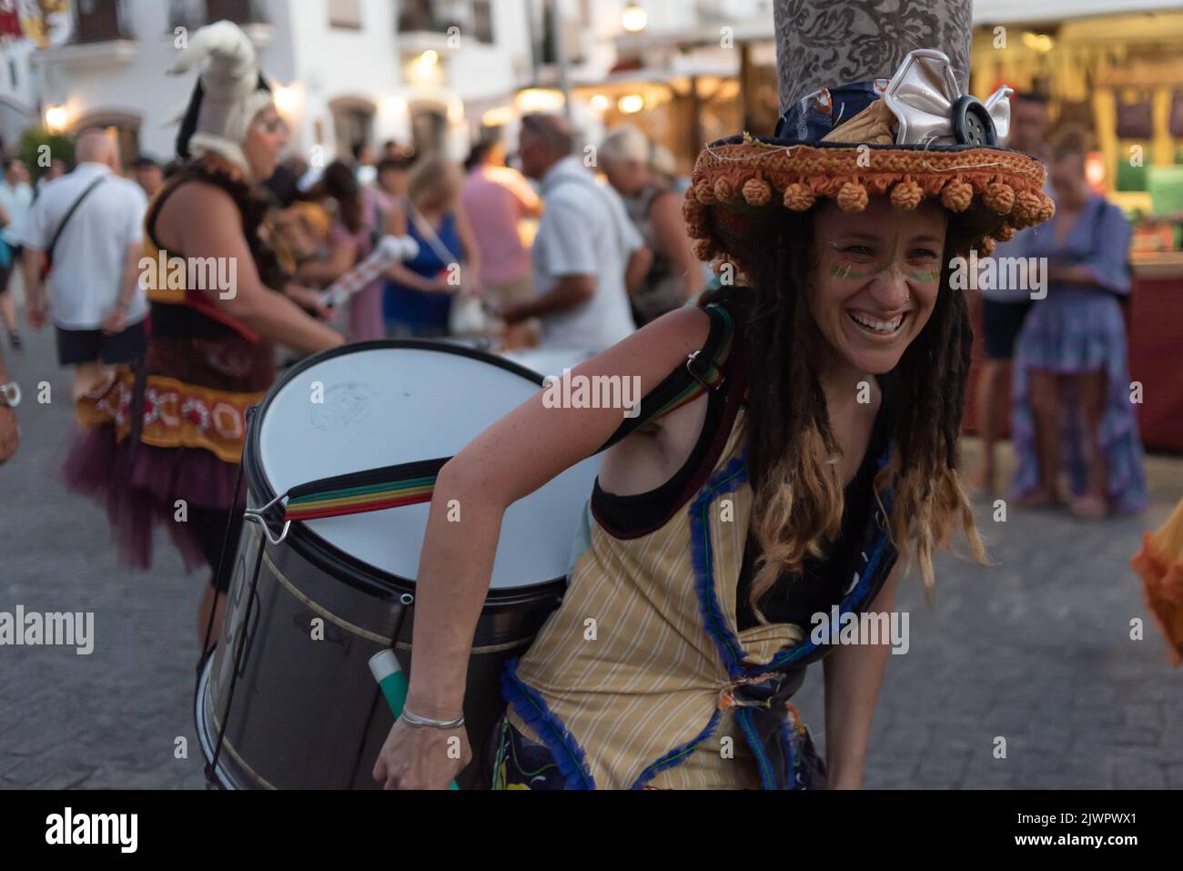 Frigiliana, Malaga, Spain, August 27, 2022: batucada street performer with big drum and big top hat with dangling tassels Stock Photo
