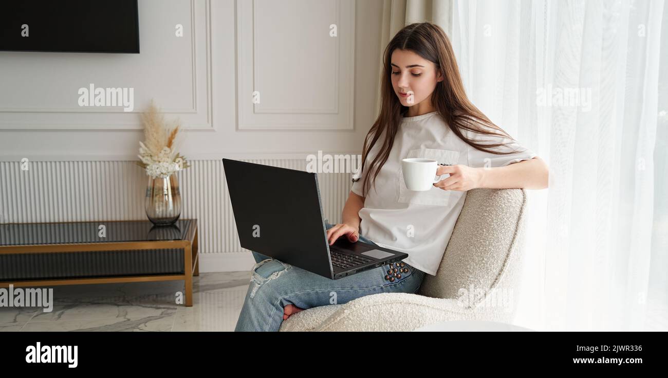 Young woman working at home by black notebook. Freelance. interior design. Stock Photo