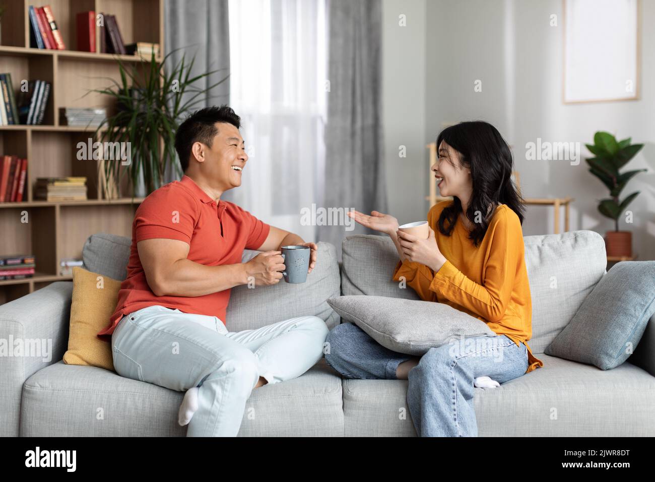 Relaxed chinese lovers enjoying conversation, drinking coffee Stock Photo